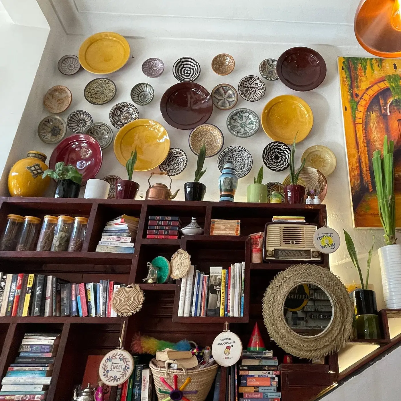 Ceramic plate wall above the book shelves at Culture Box Fès